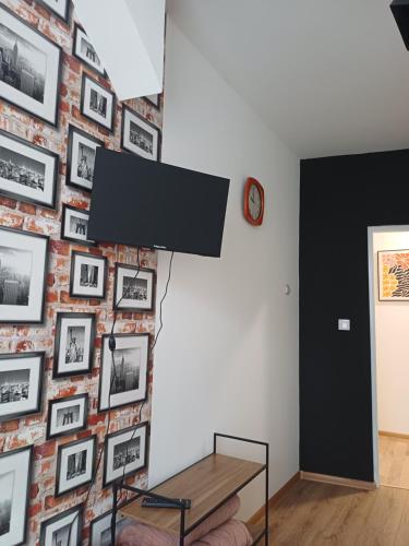 a room with a brick wall with pictures on it at Rajca Room's - Pokoje przy Jasnej Górze in Częstochowa