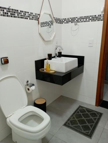 een badkamer met een wit toilet en een wastafel bij Casa de Calmaria in Cordeirópolis