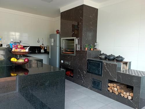 een keuken met een zwart aanrecht en een koelkast bij Casa de Calmaria in Cordeirópolis
