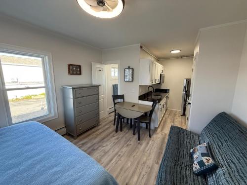 a bedroom with a bed and a table and a kitchen at Aqua Amour Studio in Old Orchard Beach