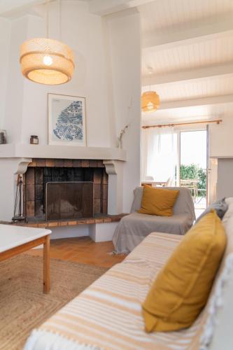 a living room with a couch and a fireplace at Le Parc des Mimosas in Noirmoutier-en-l'lle