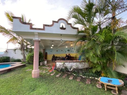 a house with a palm tree and a blue bench at Casa Vergel in Temixco