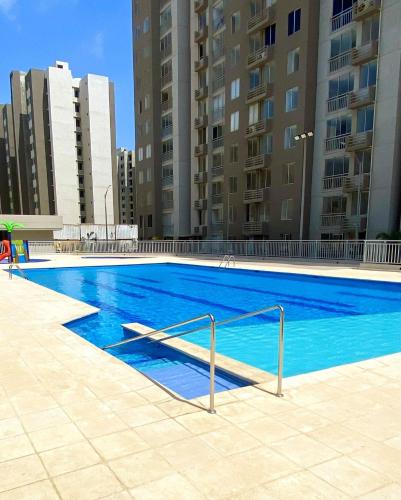 a large blue swimming pool with buildings in the background at Mirador Apartments – Excellent Location by SOHO in Barranquilla