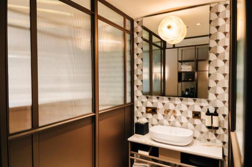 a bathroom with a sink and a mirror at The Diamond Amsterdam in Amsterdam