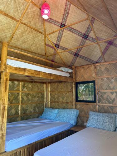 a room with two beds in a tent at Beachfront Native house with pool in Nasugbu