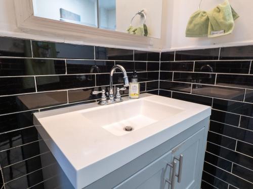 een badkamer met een witte wastafel en zwarte tegels bij New Apt in Elizabeth Railroad Style Path Train Bus Hospital Airport NYC in Elizabeth