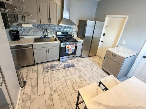 een keuken met een fornuis en een koelkast bij New Apt in Elizabeth Railroad Style Path Train Bus Hospital Airport NYC in Elizabeth