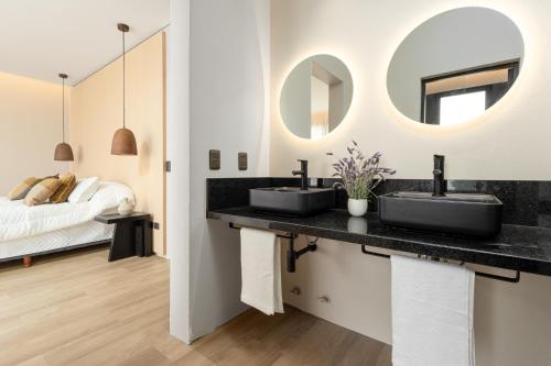 a bathroom with two sinks and a bed at Kemay Hotel Boutique in José Ignacio
