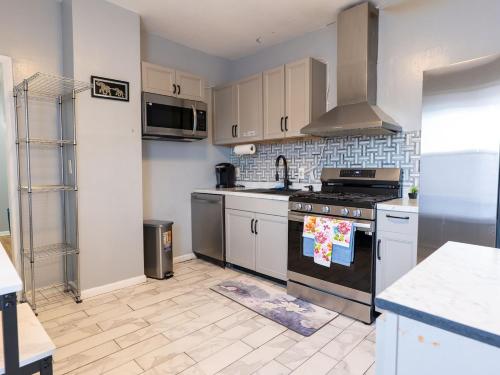 a kitchen with white cabinets and a stove top oven at New 3 BR Apt in Elizabeth Railroad Style Path Train Bus Hospital EWR Airport NJ Manhattan NYC in Elizabeth