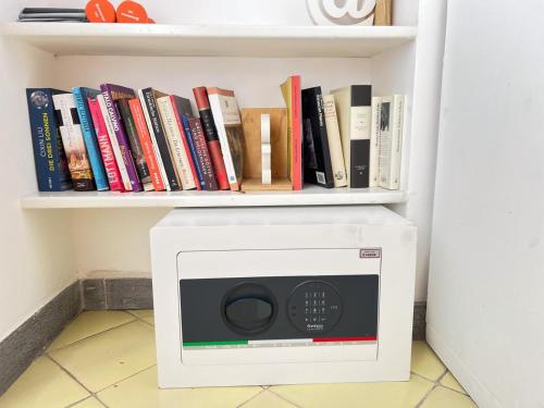 ボルセーナにあるLa terrazza di Andreaの本が置かれた棚の上の電子レンジ