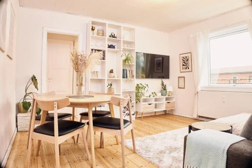 a dining room with a table and chairs in a living room at Cozy one bedroom apartment with balcony in Copenhagen