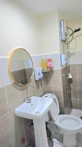 a bathroom with a toilet and a sink and a mirror at Burnham Hill 504 Baguio Condo by Dei Gratia in Baguio