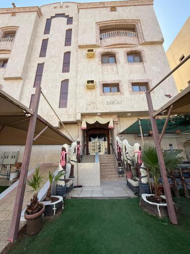 a large building with a grass yard in front of it at دار اليقين in Al Madinah