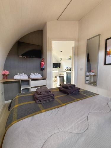 a bedroom with a bed with towels on it at Newmore Highland Pods with Hot Tubs on NC500 in Invergordon