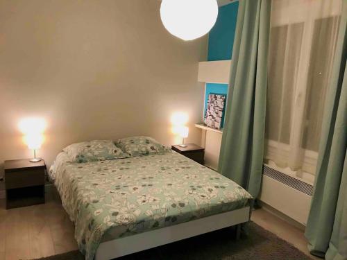 a bedroom with a bed and two lamps on tables at Agréable appartement in Bobigny