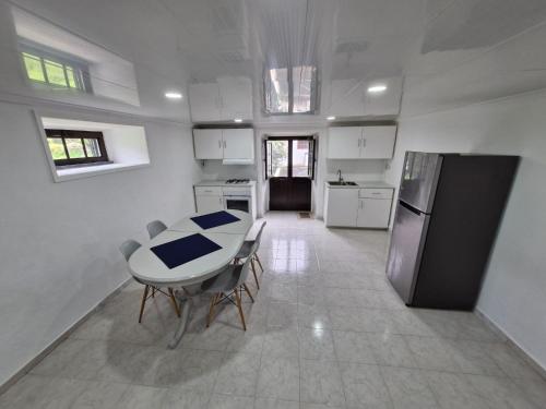 a kitchen with a table and a refrigerator at Alma Atlântica - Pure Nature & Beach in Praia do Almoxarife