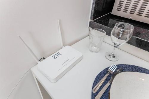 a table with a napkin and two glasses on it at Studio Vibe 2206 com Piscina/academia/varanda in Juiz de Fora
