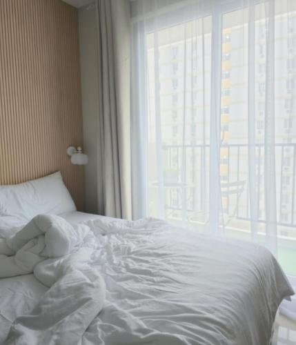 a white bed in a room with a window at Cabin916 condotel in Suba