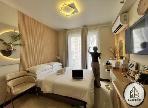 a person looking out of a window in a bedroom at Cabin916 condotel in Suba