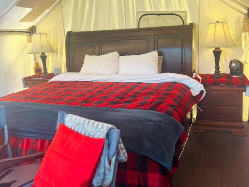a bedroom with a large bed with a red blanket at Tent 2 Oxen-Le-Fields Montana in Conner
