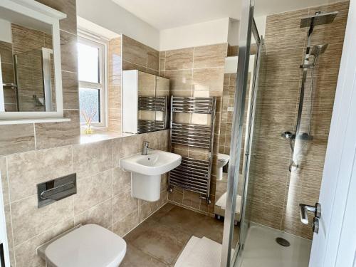 une salle de bain avec toilettes, lavabo et douche dans l'établissement Salford Detached House with Ensuite King Room, à Manchester