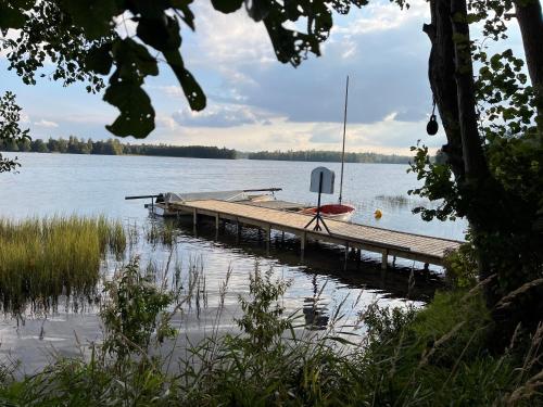 a dock on a lake with a boat on it at Malëna Mausz in Parchowo