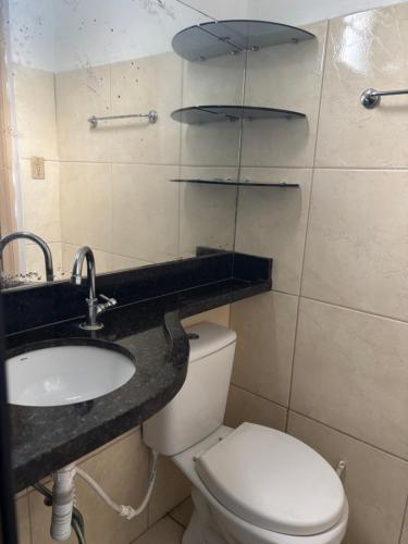a bathroom with a white toilet and a sink at Casa 28 de agosto climatizada e aconchegante in Manaus