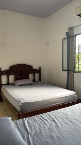 a bedroom with two beds and a window at Casa 28 de agosto climatizada e aconchegante in Manaus