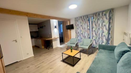 a living room with a blue couch and two chairs at Apartamenty Dąbrówka Beauty - w parku leśnym , sauna in Jelenia Góra