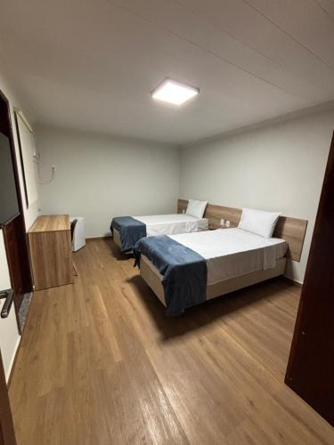 a room with two beds and a television in it at 44 Residence in Belém