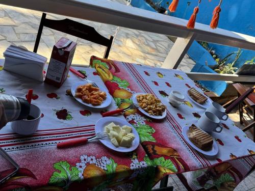 ein Tisch mit Tellern voller Essen darauf in der Unterkunft Hospedagem La Casa Agus Buzios in Búzios