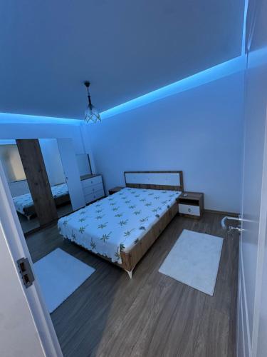 a bedroom with a bed and a blue light at Emir's Apartment in Pristina