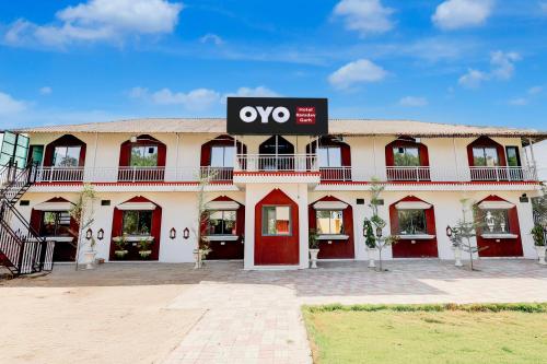 ein großes weißes Gebäude mit einem Schild darauf in der Unterkunft Hotel O RamdevGarh Resort in Ahmedabad