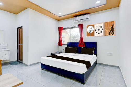 a bedroom with a large bed in a room at Hotel O RamdevGarh Resort in Ahmedabad