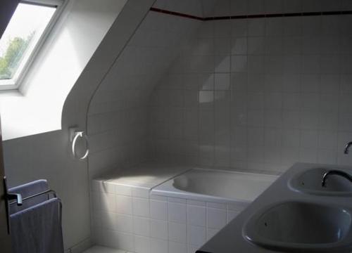 une salle de bain blanche avec une baignoire et un lavabo dans l'établissement Komforthaus Mit Traumgarten Und Meerblick, à Plouha