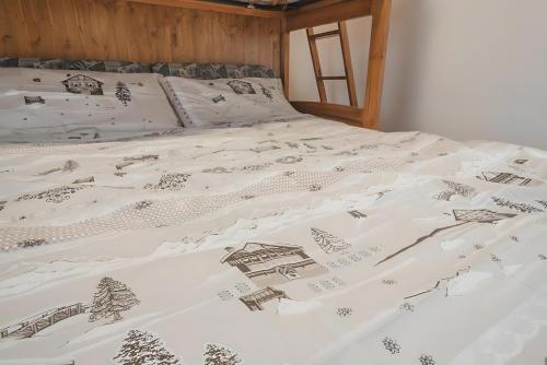 a bed with a white comforter with a drawing on it at Appartamenti Pila Vacanze 2 in Cerise