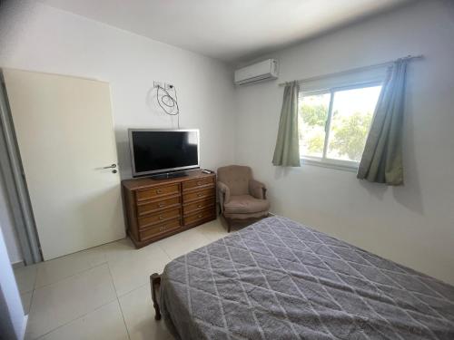 ein Schlafzimmer mit einem Bett, einem Fernseher und einem Stuhl in der Unterkunft La Juanita in San Juan