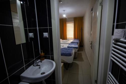 a bathroom with a sink and a bed in a room at Home 22 Otel in Edirne