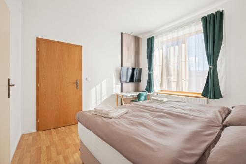 a bedroom with a large bed and a window at Ubytování Dva v centru in Velké Meziříčí