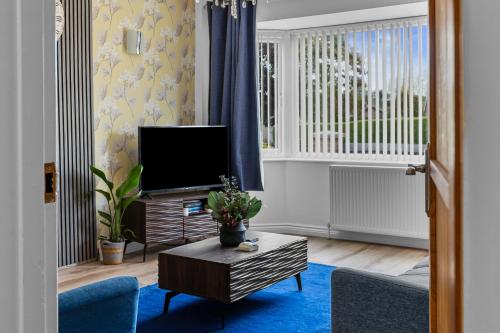 a living room with a tv and a blue rug at Greenview in Spinney Hill