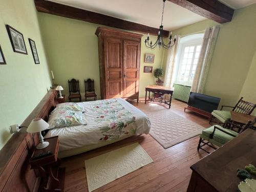 Un dormitorio con una cama y una mesa y sillas. en Chambre Chez L'habitant, en Sermérieu