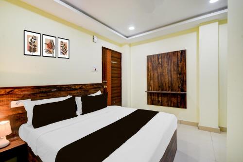 a bedroom with a black and white bed and a window at Hotel O Hotel R Pacific in Hyderabad