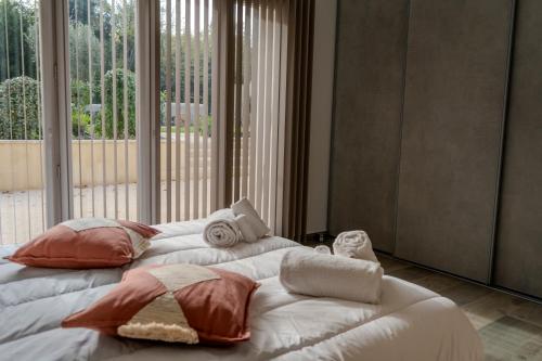 阿维尼翁新城Château de l'insolas的一张大床，上面放着枕头，床边有一扇大窗户。