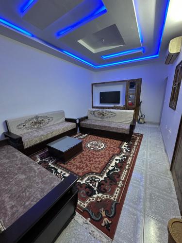a room with two beds and a flat screen tv at Dar Ben Othman in Tozeur