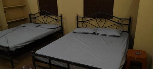 two twin beds in a room with at F & N Stay in Tiruvannāmalai