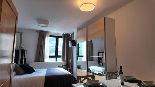 ein Hotelzimmer mit einem Bett und einem Spiegel in der Unterkunft Apartamento Premium Snow Gorbea - Vistas a pistas, wifi y parking gratis Zona Baja in Sierra Nevada