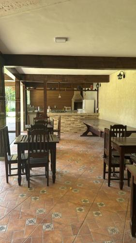 a dining room with wooden tables and chairs at Pousada Spazio San jose in Saquarema