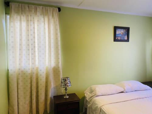 un dormitorio con una cama y una ventana en Gran Via Hostel, en Punta Arenas