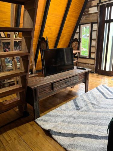 een woonkamer met een tv op een houten tafel bij Recanto - Chalé Boa Vista in Jaraguá do Sul