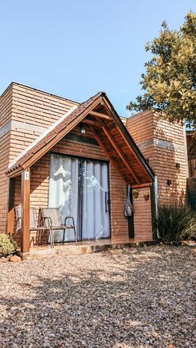 a brick house with a window and a chair at Chalés Manacá dos Canyons in Praia Grande